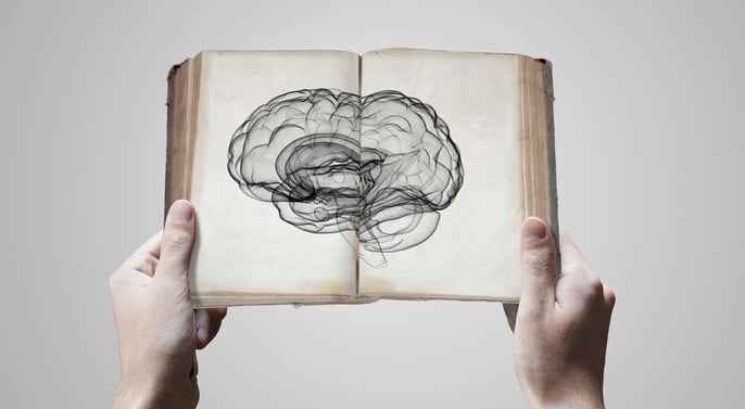 Close up of male hands holding opened book with brain picture-crop.png