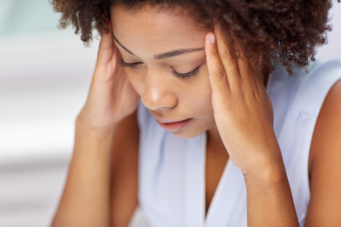 young woman holding head with headache